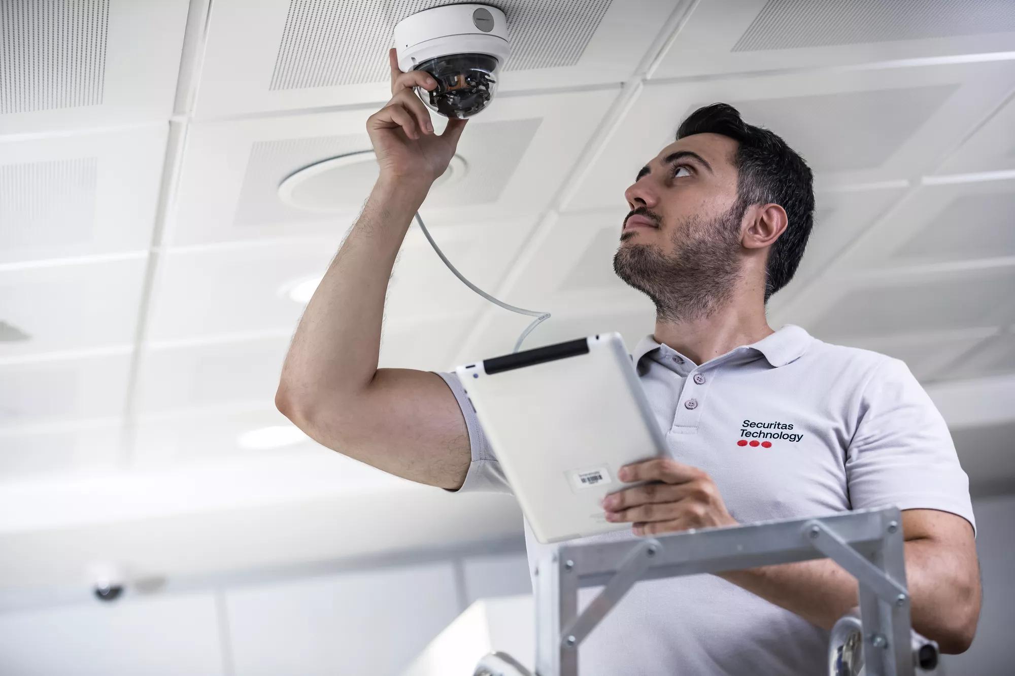 Securitas technician installing security camera