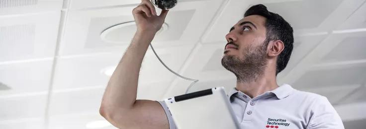 Securitas technician installing a security camera