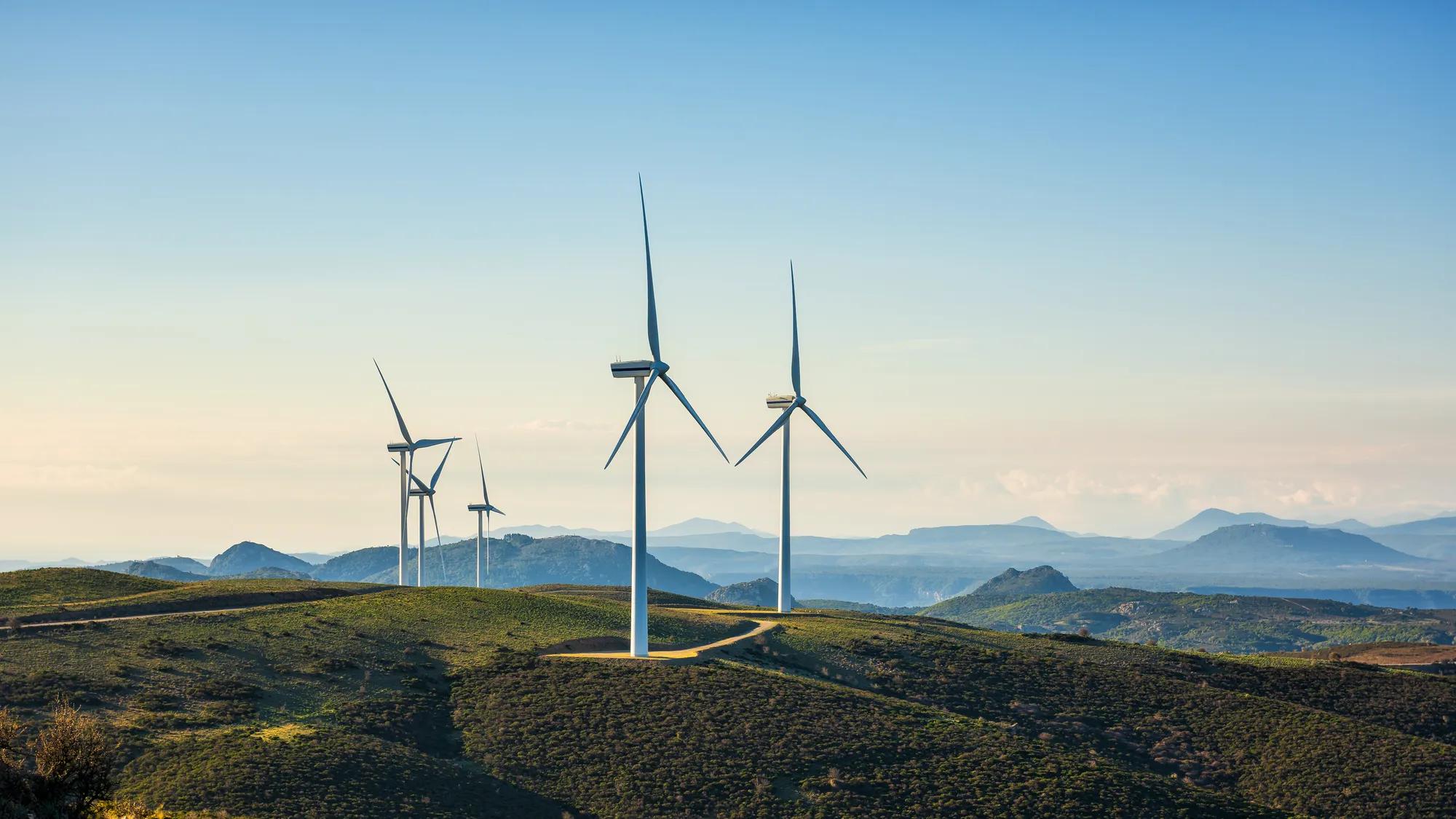 Wind turbines on a beautiful blue sky in a mountain wind farm in Sardinia. Renewable energy concept, green energy generation. Energy industry.