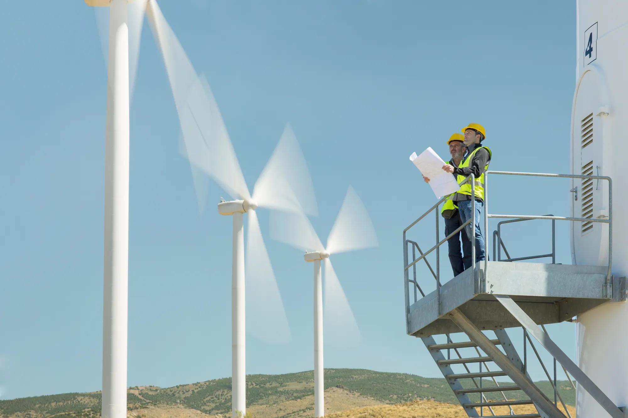 Wind farm with turbines under blue sky representing critical infrastructure security and physical energy security