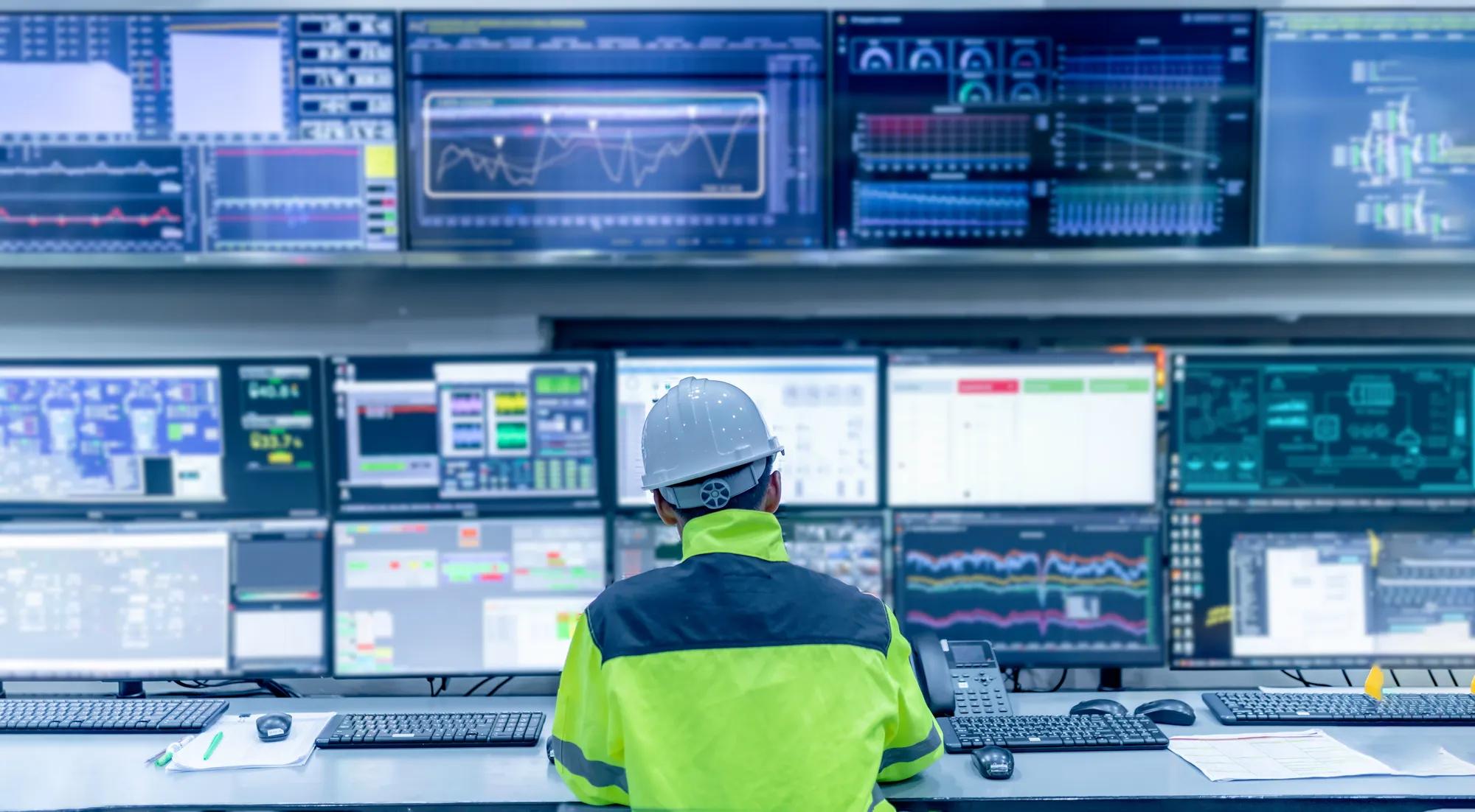 Technician monitoring control room technology to enhance energy security for critical infrastructure.