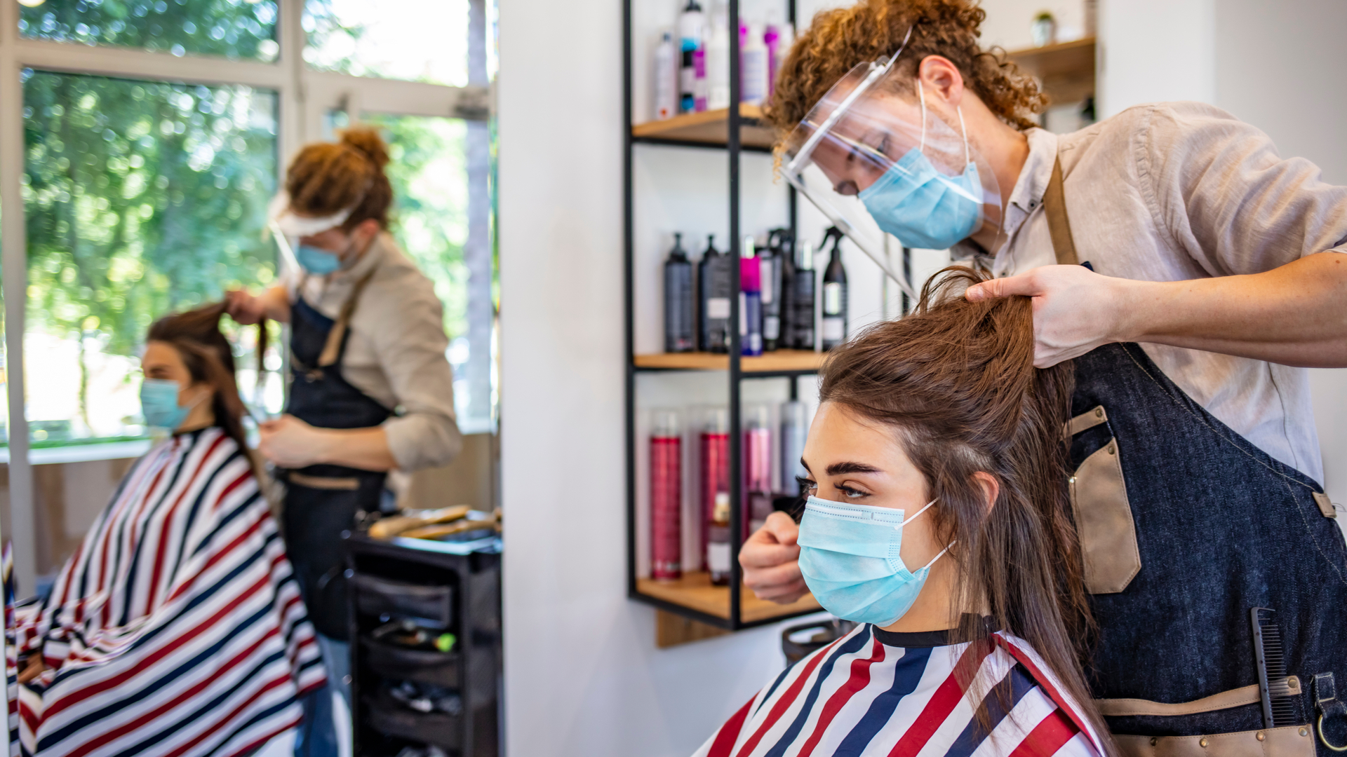 Woman wearing face mask while getting a haircut
