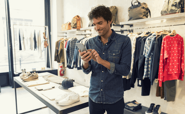 Man uses smartphone in retail shop