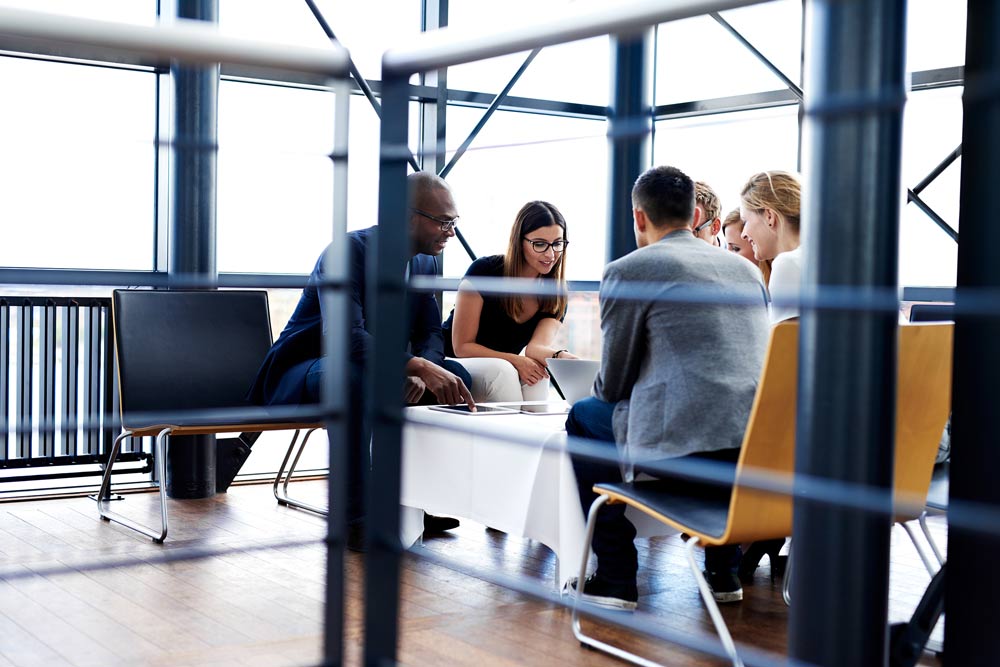 Employees sit around table