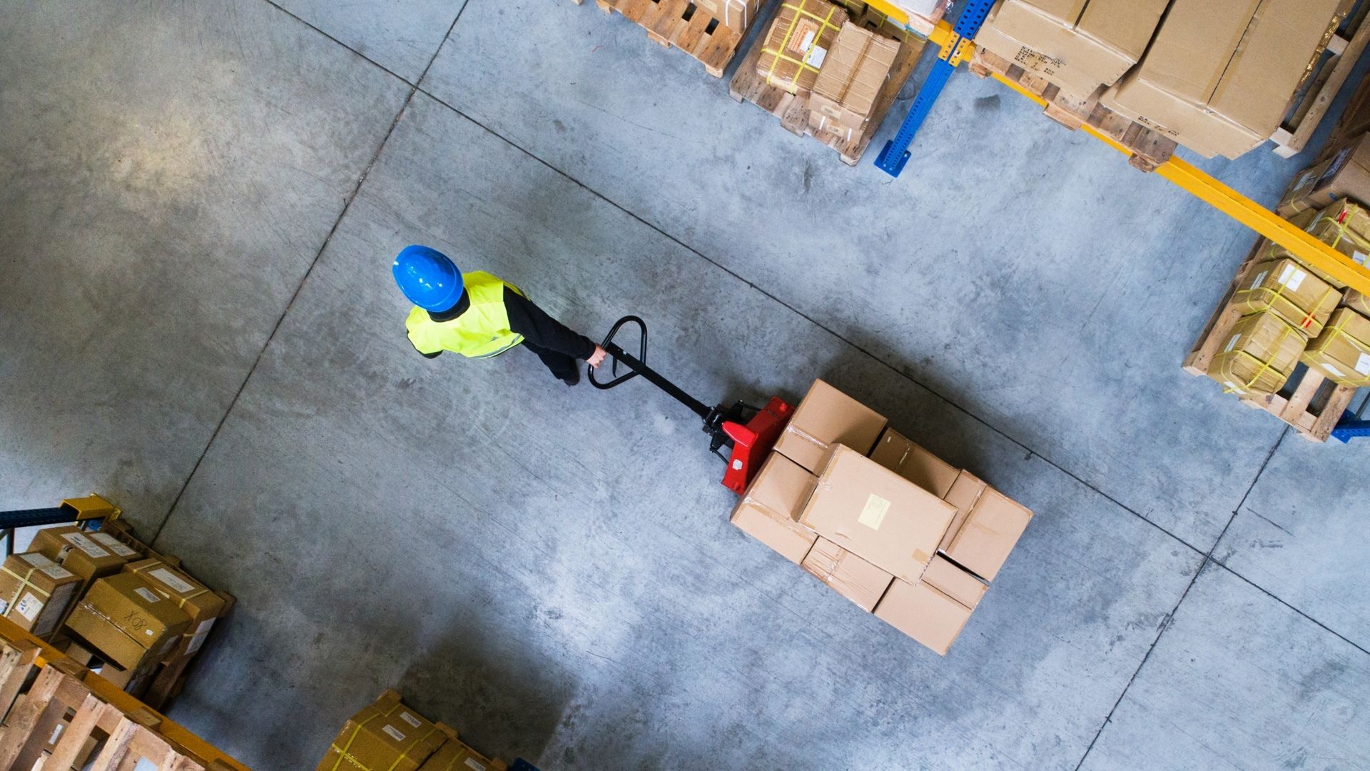 Warehouse worker pulls boxes on dolly