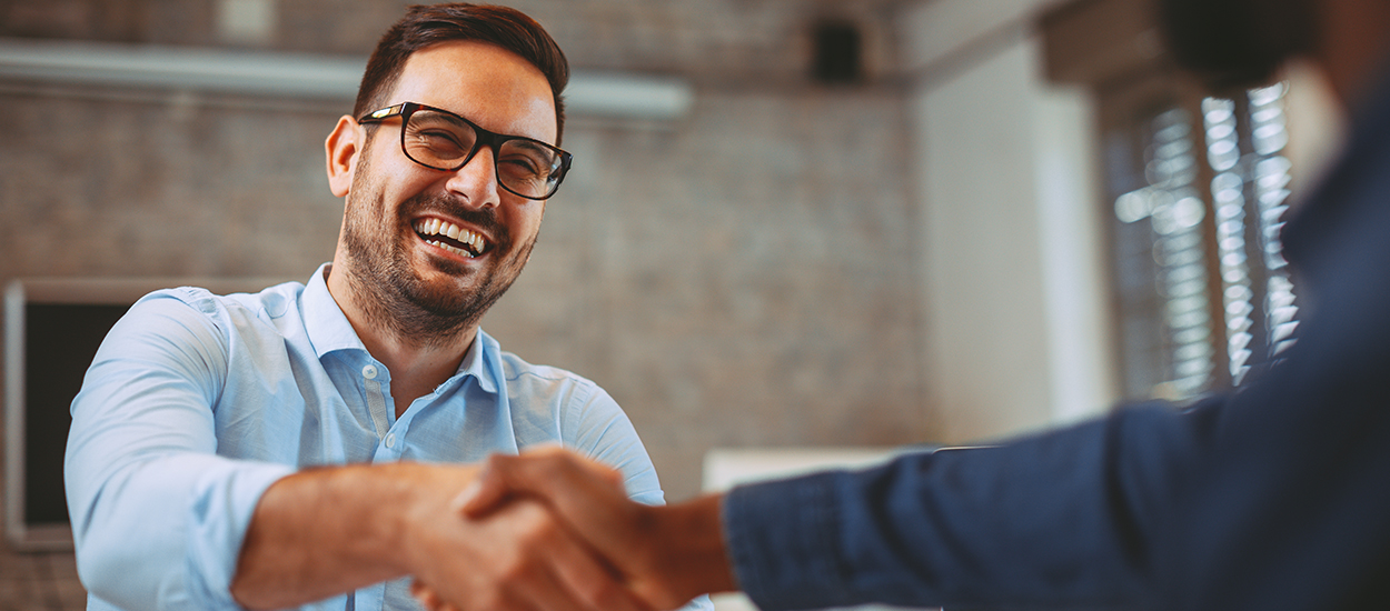 Smiling man shakes hands