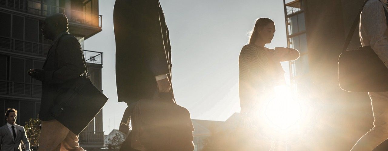 People walking with sun behind