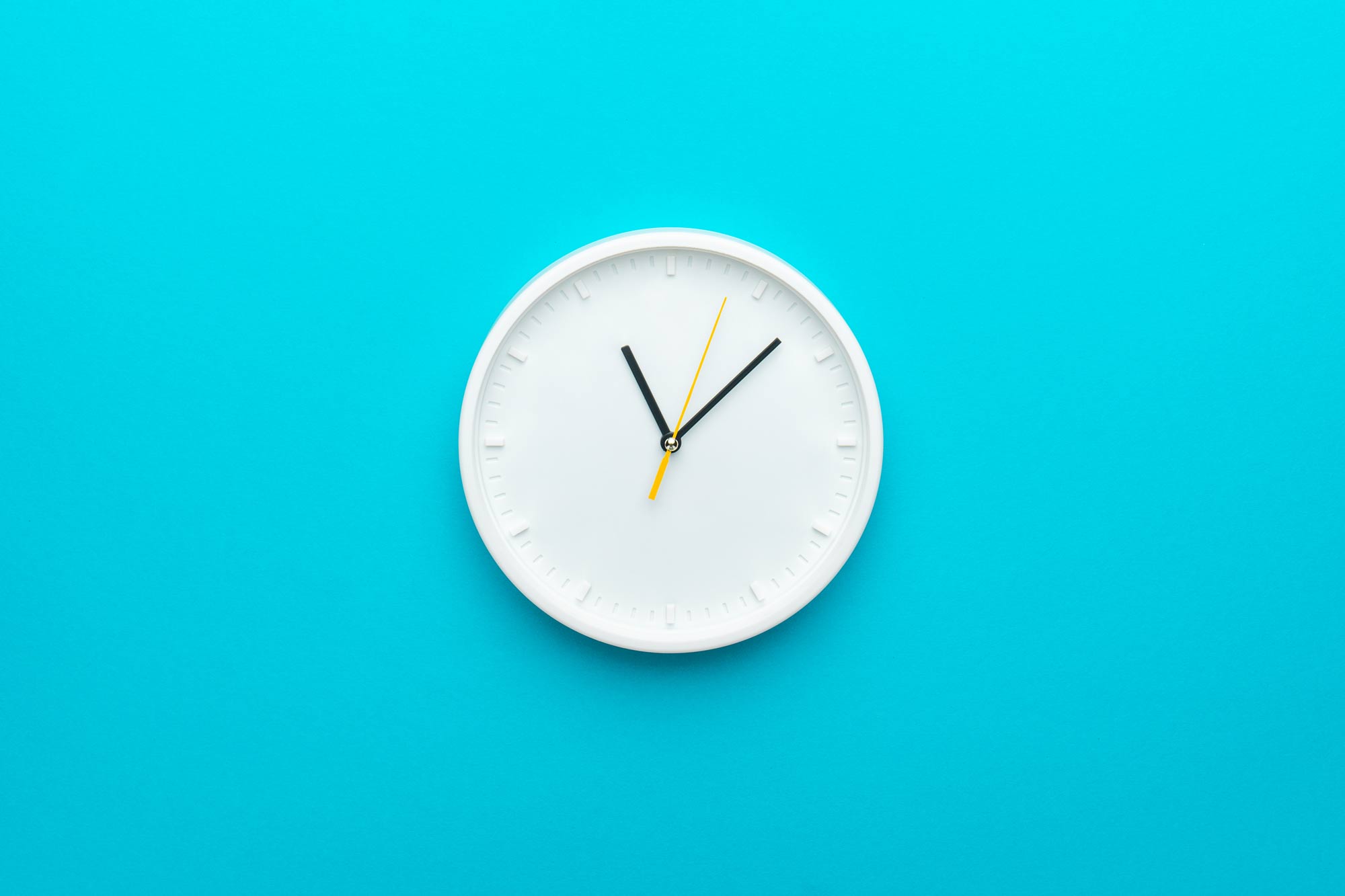 Clock hanging on blue wall