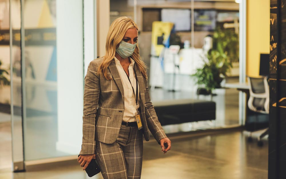 Masked woman walks through lobby