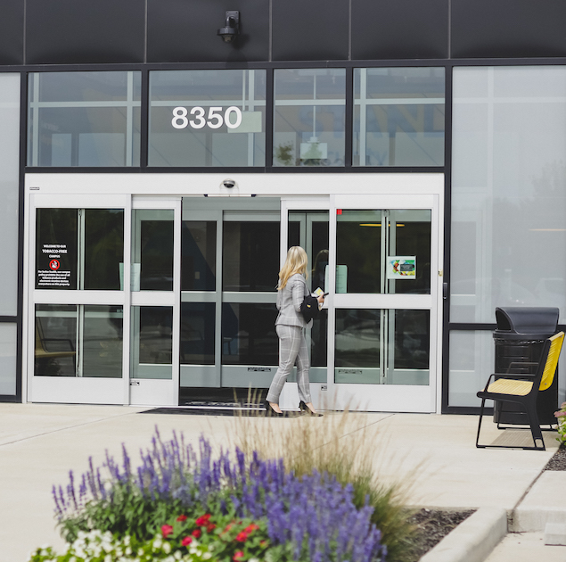 Woman enters automatic doors of building.