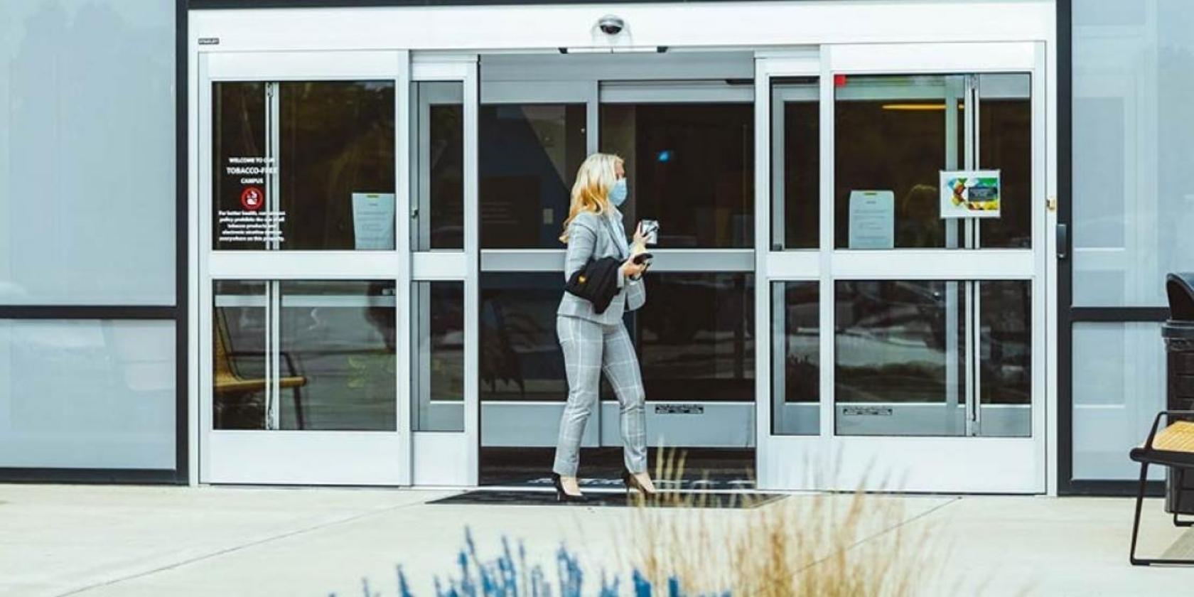 Woman entering building through external door using access control card