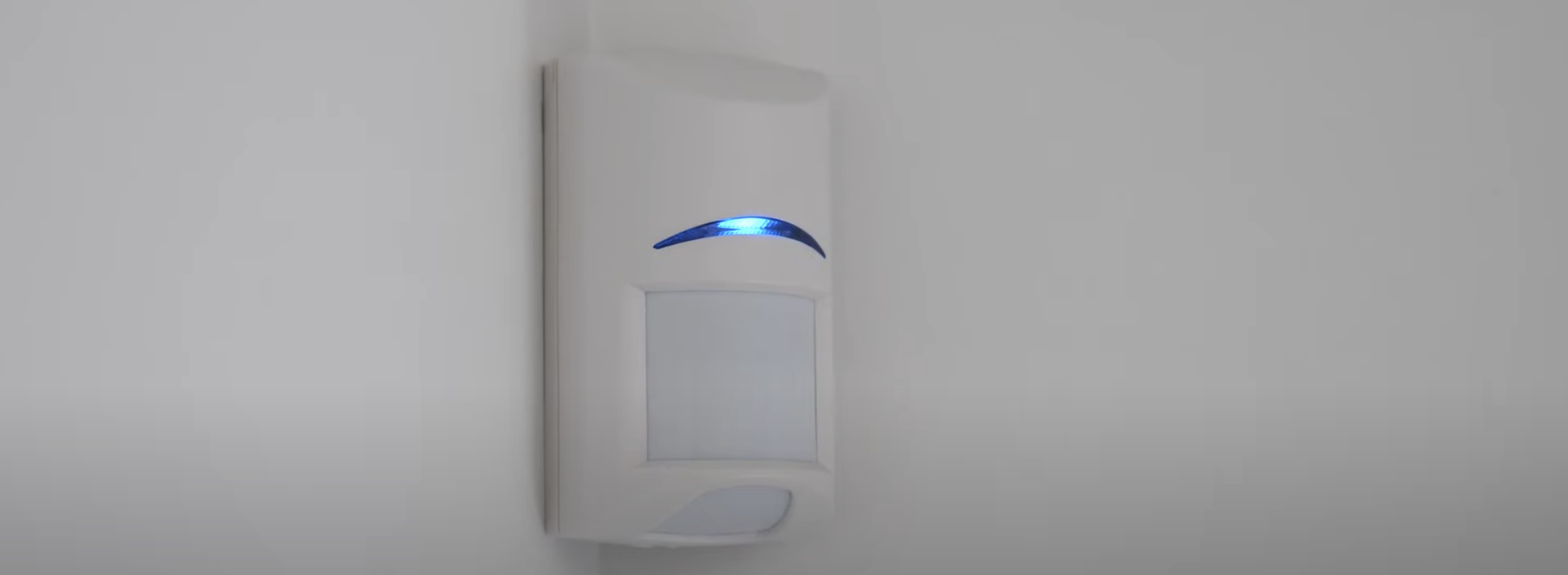 Burglar alarm mounted in corner of room.