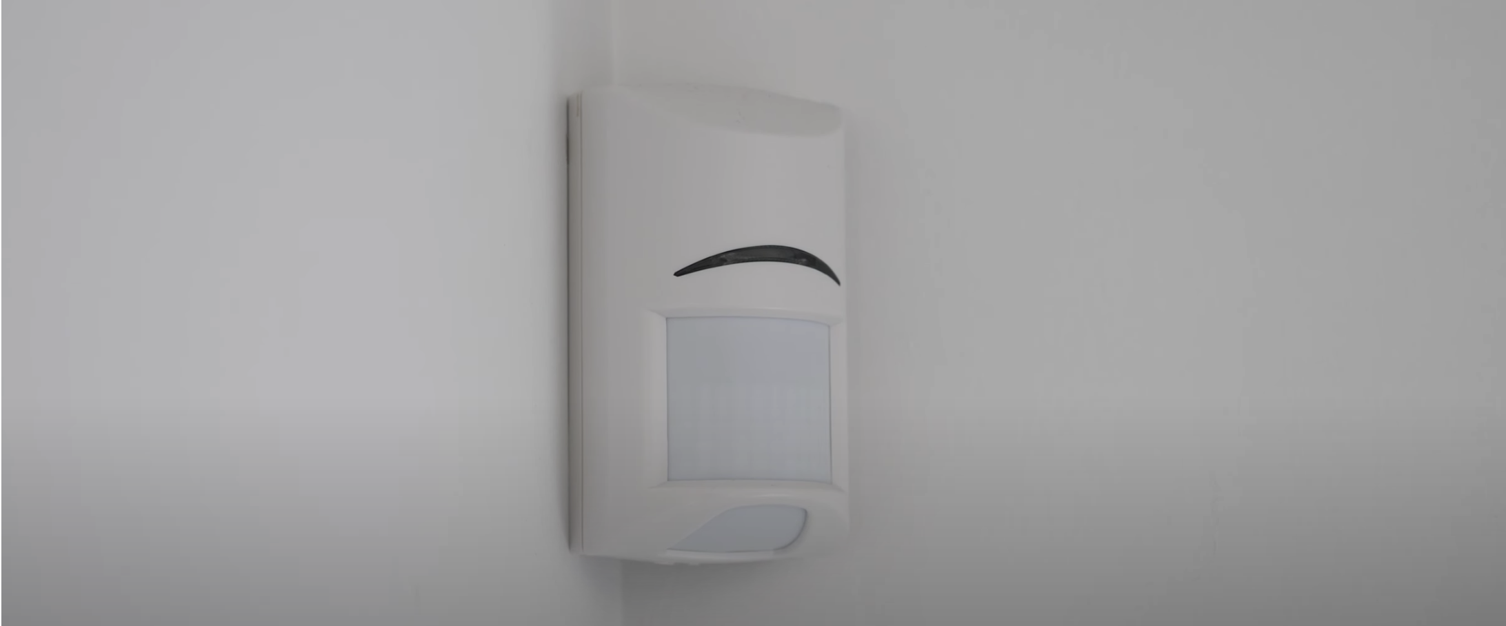 Motion sensor mounted in corner of room.