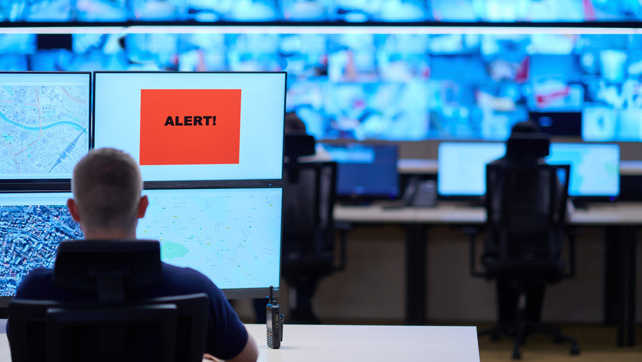 Male security operator working in a data system control room offices Technical Operator.jpg