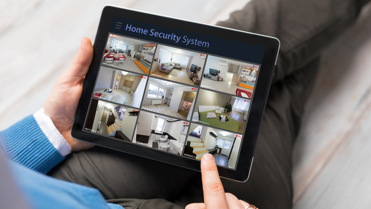Man looking at home security cameras on tablet computer.png