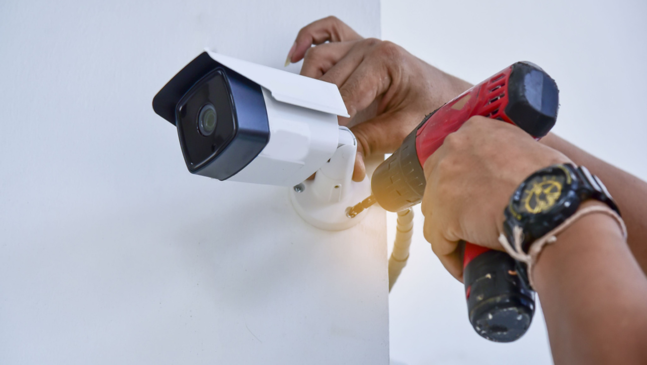 Technician installing CCTV camera for security