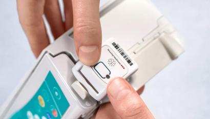 Engineer mounting Securitas Healthcare asset management tag to infusion pump