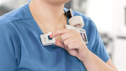 Nurse pressing button of Securitas Healthcare staff protection tag to call for assistance