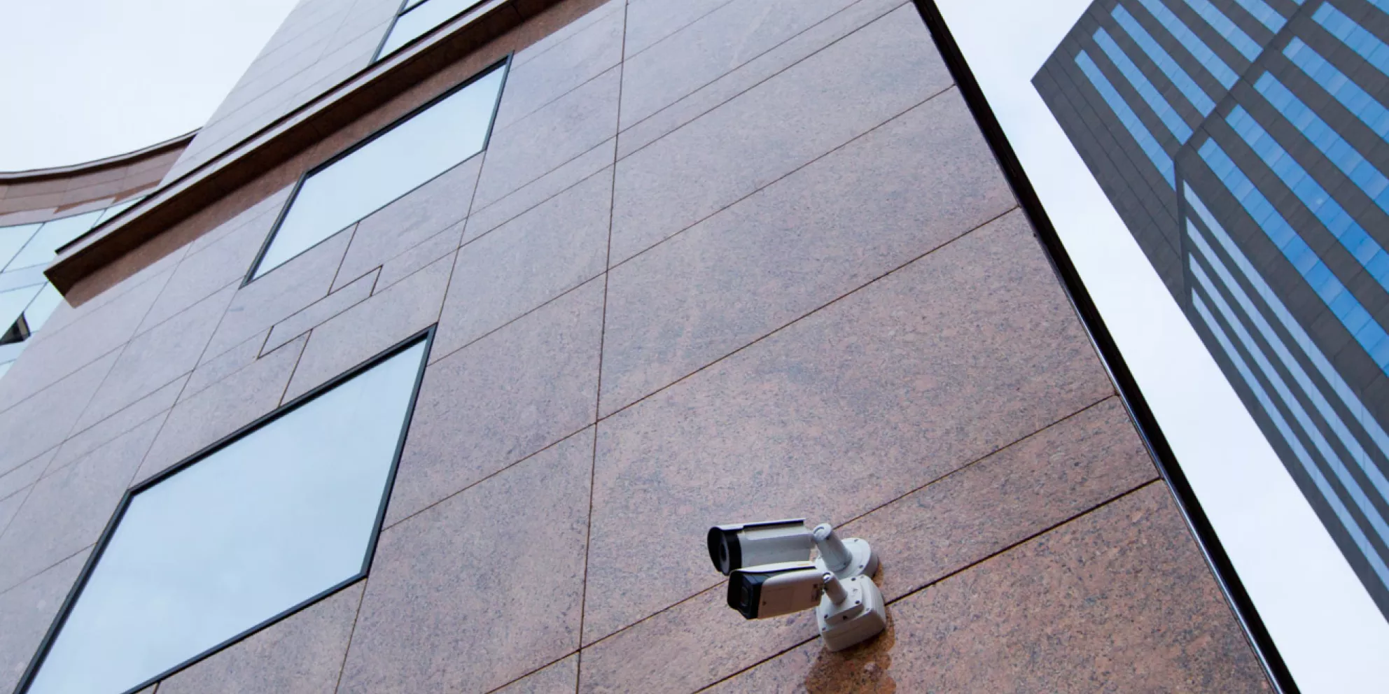 Security camera mounted on wall of tall building