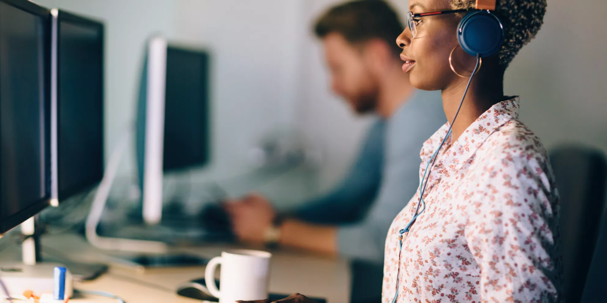 Woman at computer desk wearing headset