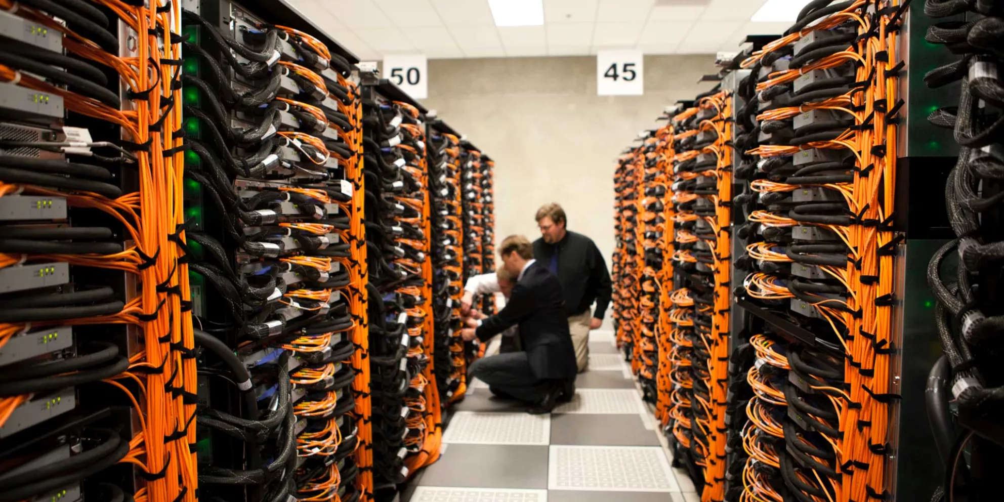 Two people sit in aisle between server rows