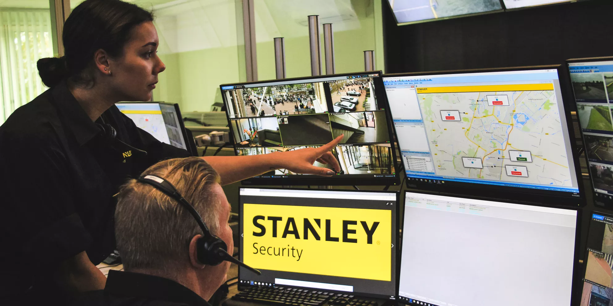 EU monitoring center with two STANLEY workers reviewing monitors