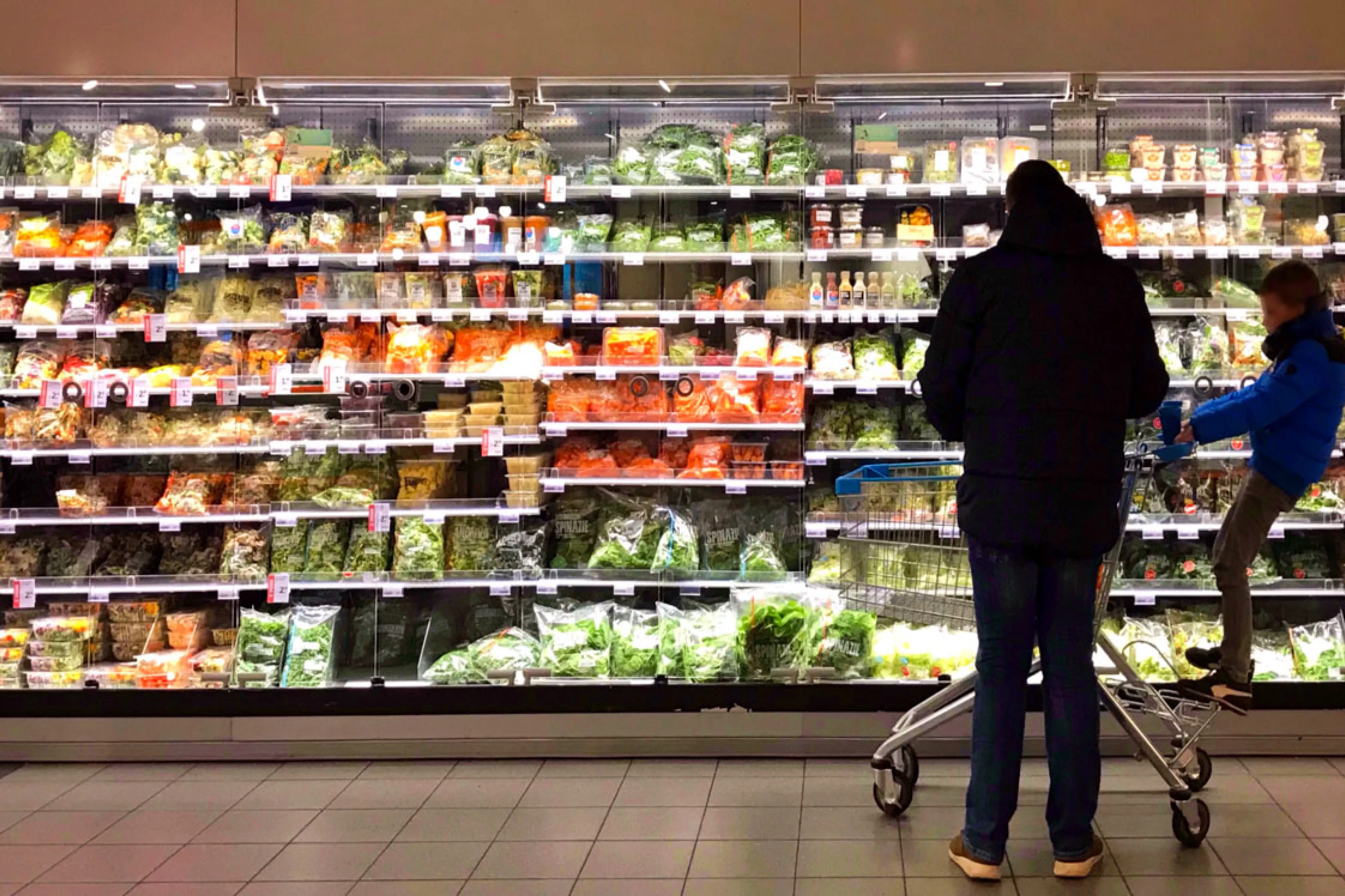 Parent and child in front of produce shelf
