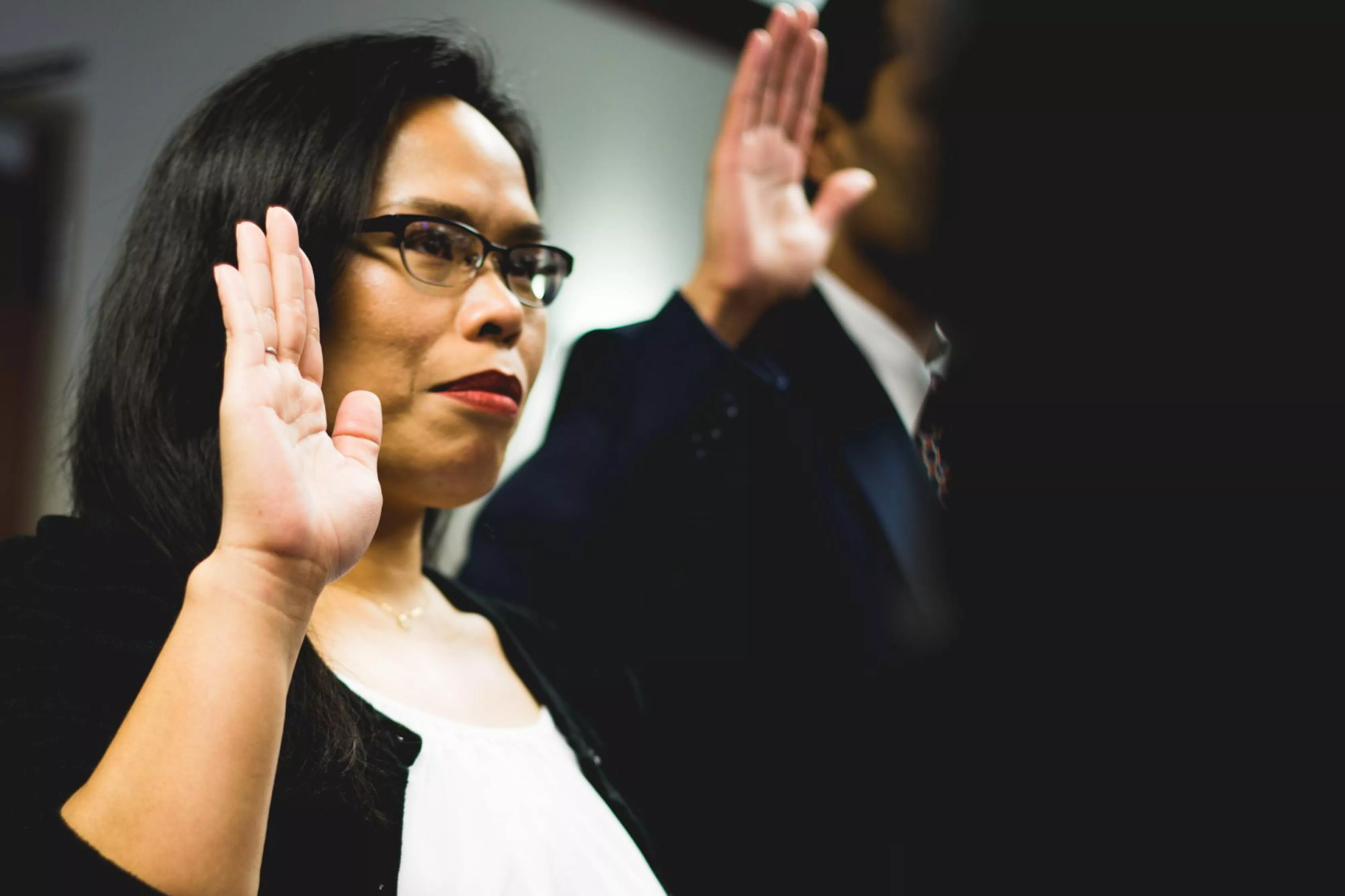 Woman holds up hand in pledge