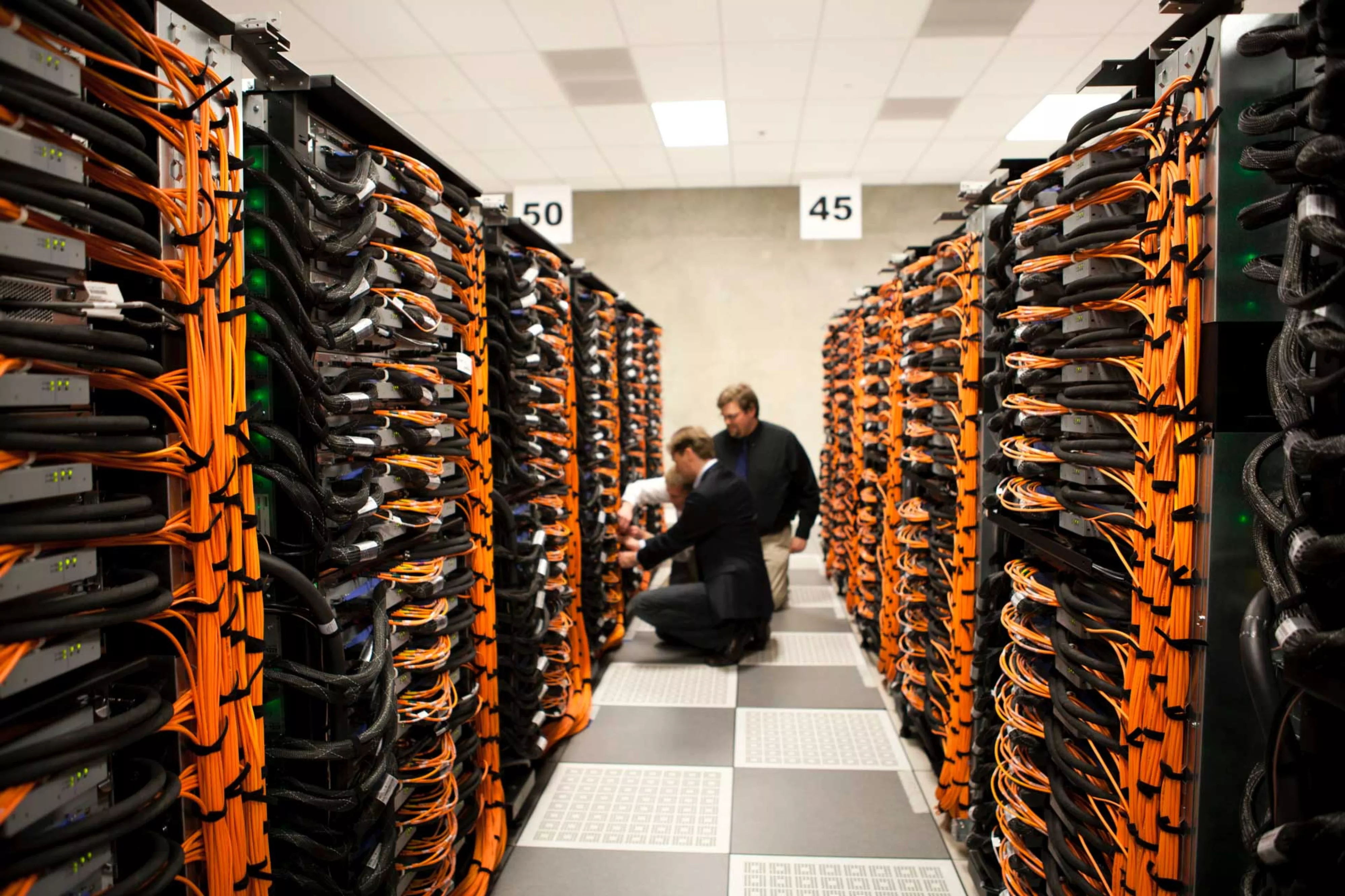 Two people sit in aisle between server rows