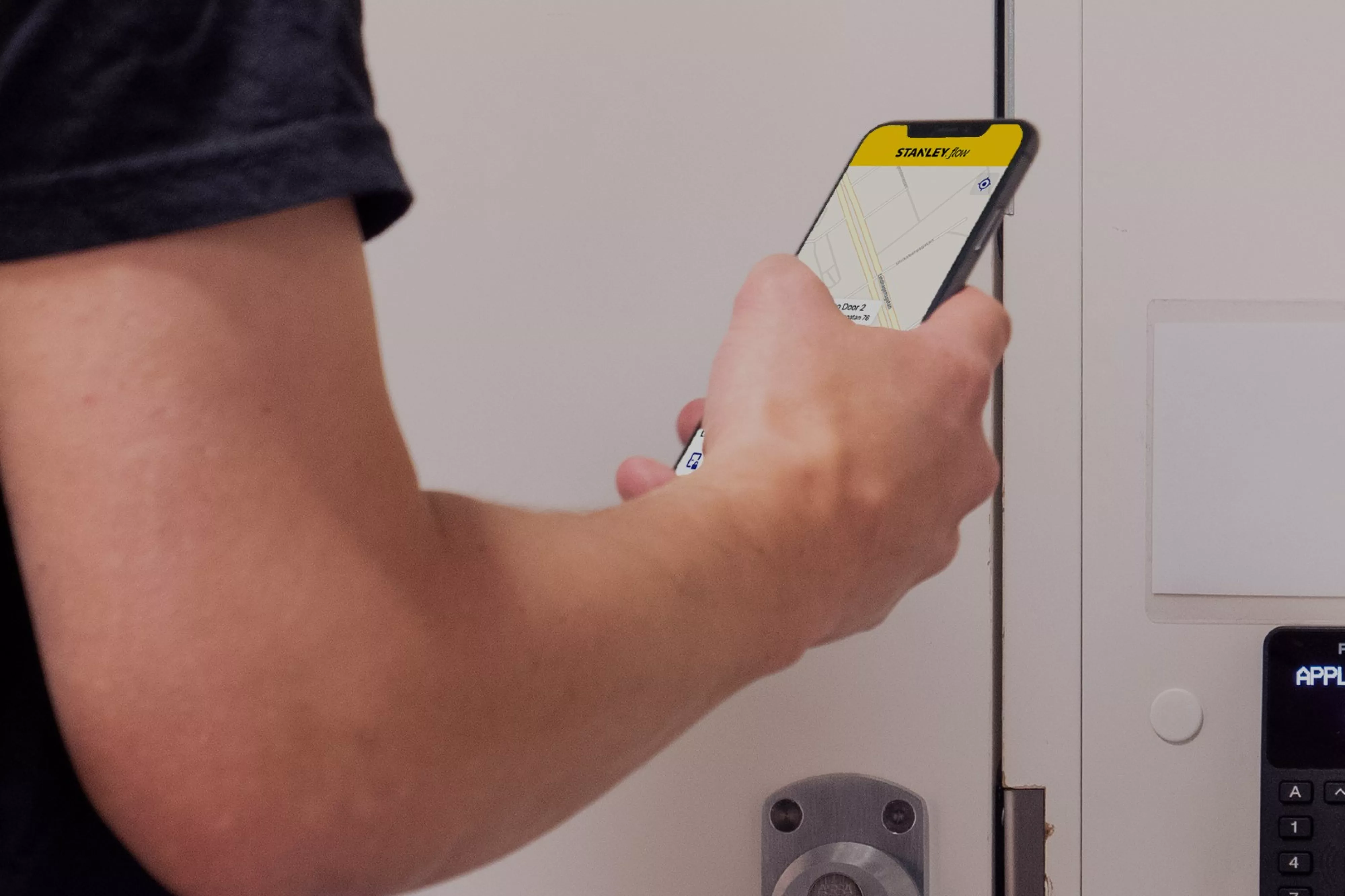 STANLEY Flow hero image Man using Mobile Phone Card Reader Access Control