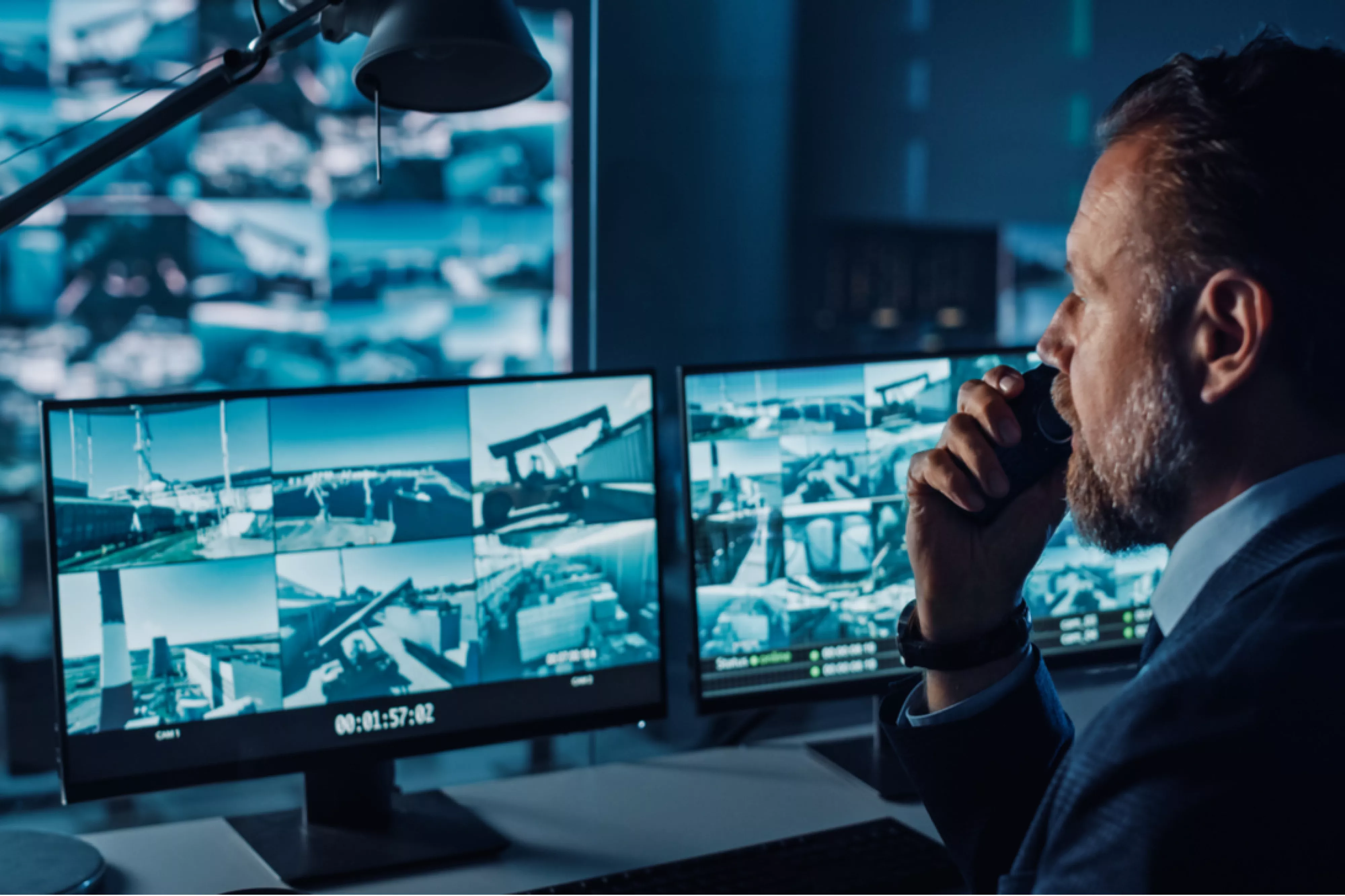 Male Officer Works on a Computer with Surveillance CCTV Video
