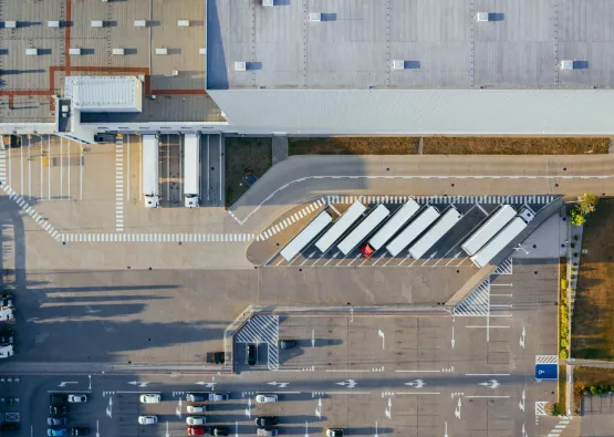 Logistiek terrein van bovenaf met vrachtwagens en parkeervlakken.