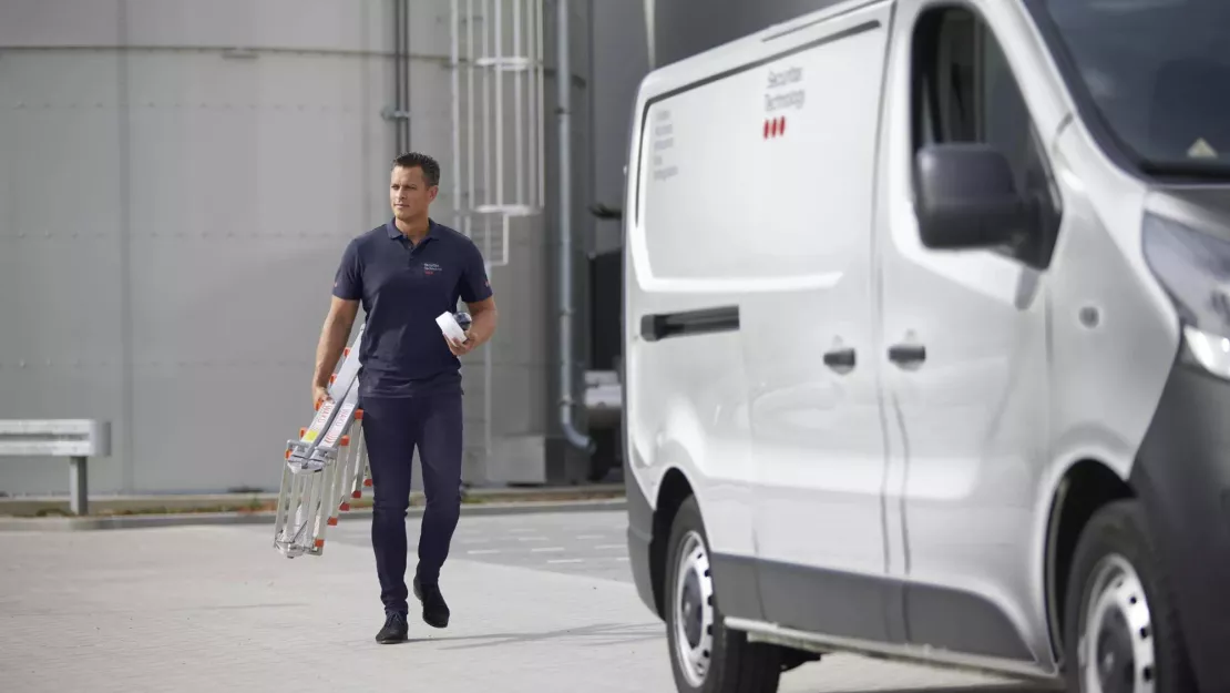 Monteur loopt naar zijn werkbus