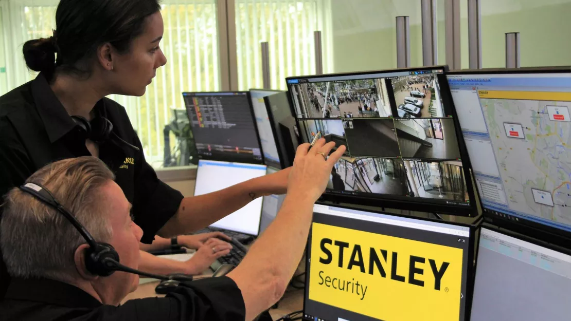 STANLEY Security employees look at camera monitors