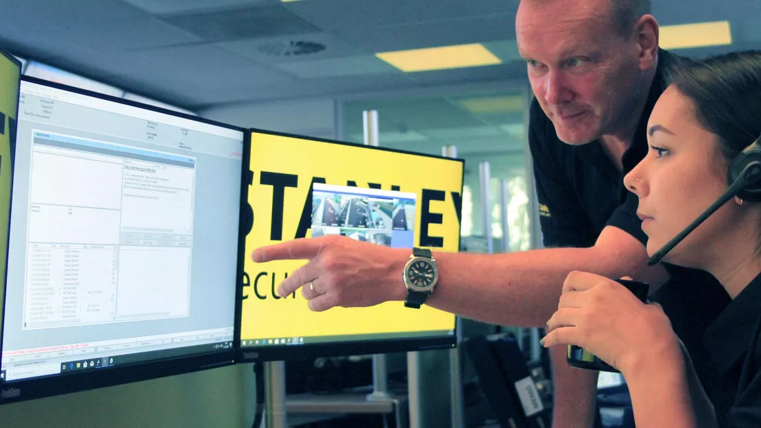Security employee points toward monitor