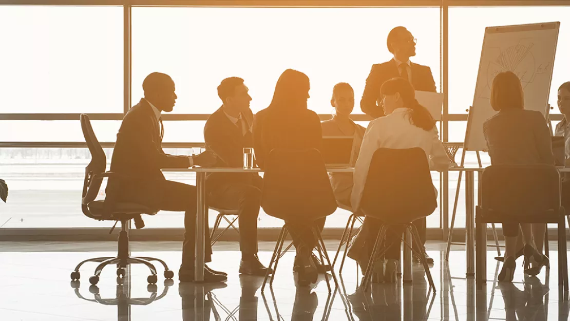 employees meeting by a large window