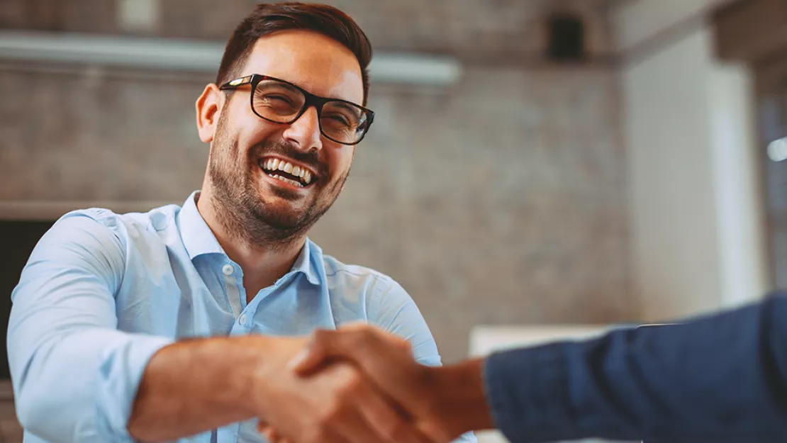 Smiling man shakes hands
