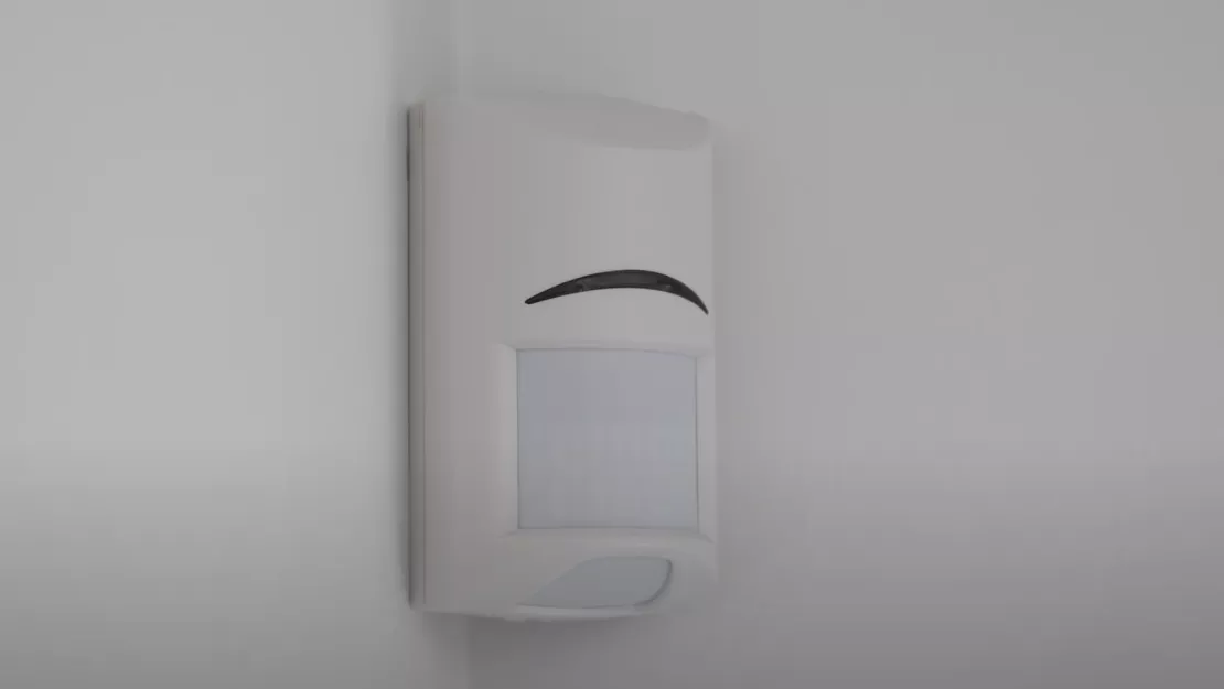 Motion sensor mounted in corner of room.