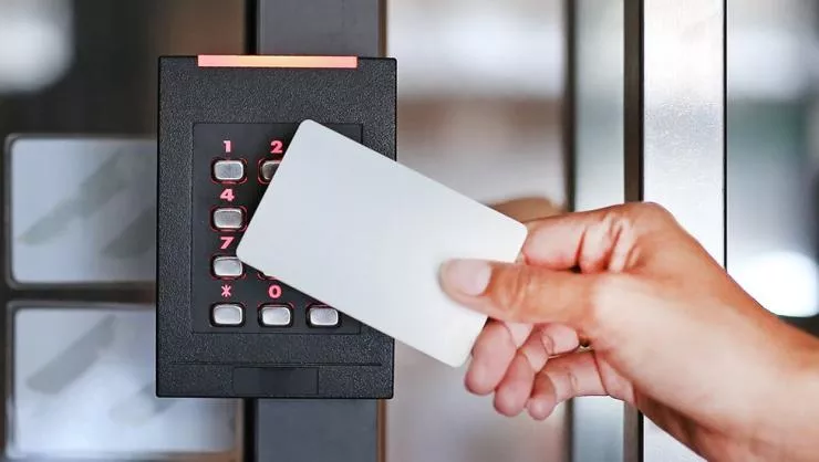 person swiping access card across access control card reader 