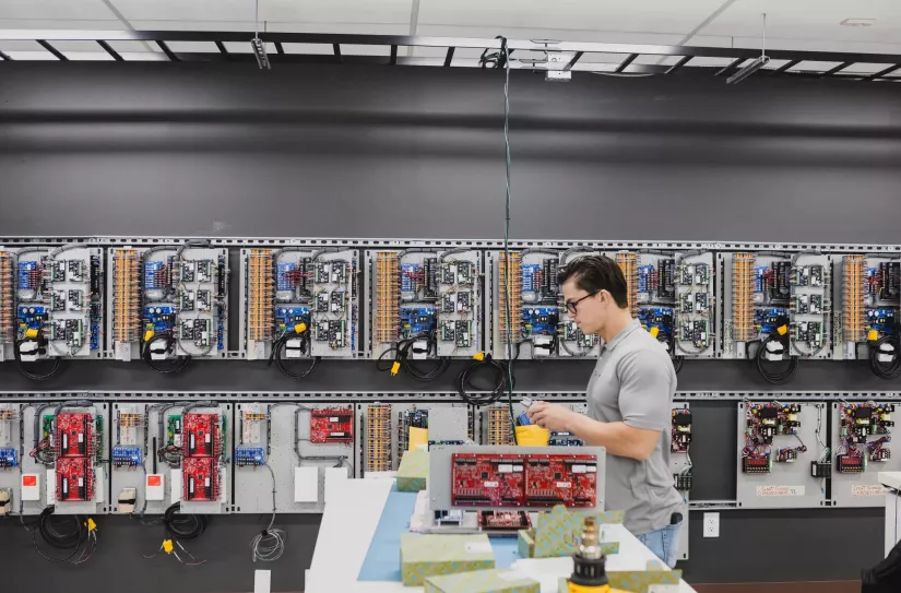 En tekniker arbejder på et værksted med at samle noget elektronik	