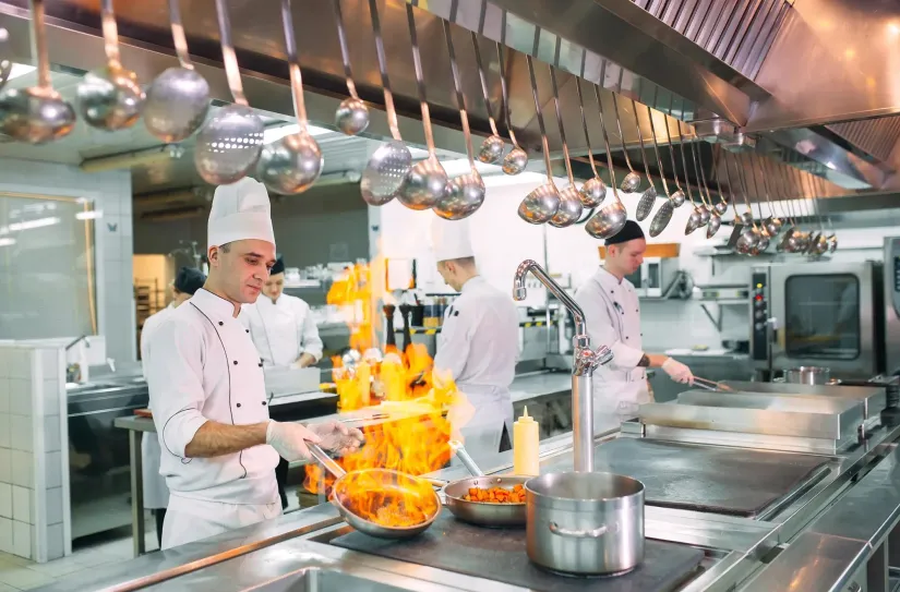 Modern kitchen. Cooks prepare meals on the stove in the kitchen of the restaurant or hotel. The fire in the kitchen