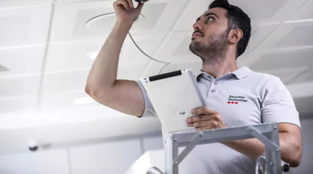 Securitas technician installing security camera