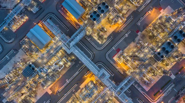 Aerial top view oil and gas refinery plant form industry zone at night.