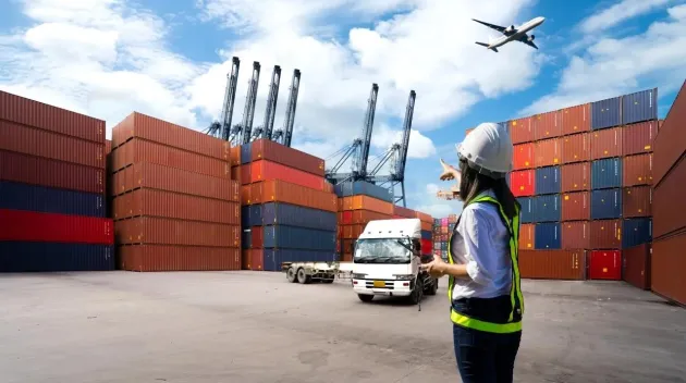 Foreman Woman control loading Containers box from Cargo freight ship for import export.