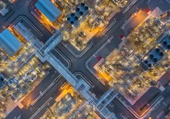Aerial top view oil and gas refinery plant form industry zone at night.