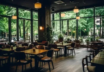 Large spacious empty cafe or restaurant with huge windows overlooking the garden.