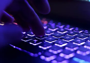 Working on a neon computer keyboard with colored backlighting. Computer video games, hacking, technology, internet concept. Selected focus. High quality photo