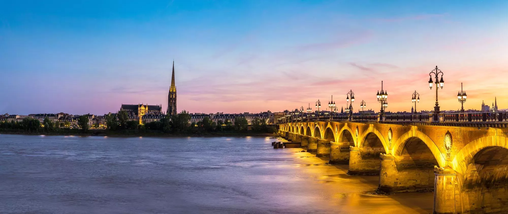 Panorama of Pont de pierre, old stony bridge in Bordeaux in a beautiful summer night, France