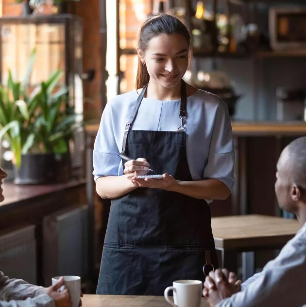 Waitress female welcoming diverse cafeteria pub guests african guy mixed race girl making order waiting staff writing wishes on notepad. Good service dining time, friends meets in public place concept