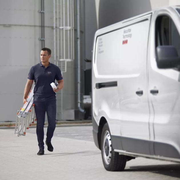 Monteur loopt naar zijn werkbus